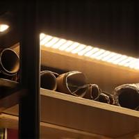 Under-shelf LED lighting illuminating stored items on a shelf